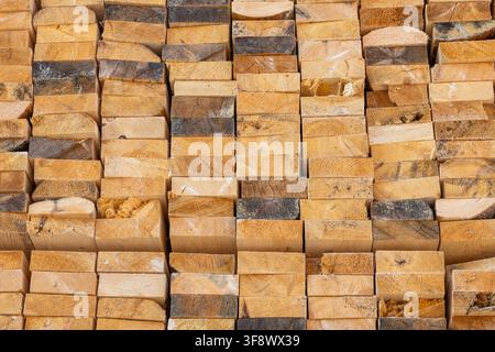 Detaillierte Ansicht von oben auf einen großen Stapel grob geschnittener Holzplanken. Das Bild betont die Textur, die Maserungen und die natürlichen Farbvariationen von Stockfoto