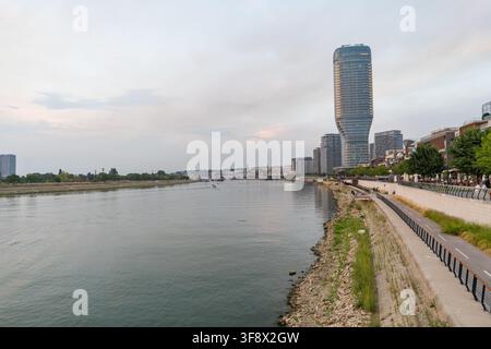 Eine Weitwinkelaufnahme des modernen Kula-Belgrad-Turms, der am Ufer der Sava in Serbien hoch aufragt. Die Uferpromenade erstreckt sich entlang d Stockfoto