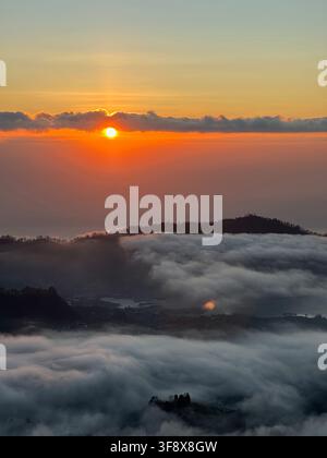 Sonnenuntergang über dem Wolkenmeer am Mount Batur, Bali, Indonesien Stockfoto
