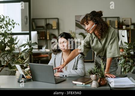 Verschiedene weibliche Kollegen besprechen ein Projekt auf dem Laptop-Bildschirm Stockfoto