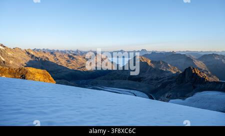 Die frühmorgendliche Sonne erhellt die atemberaubende Weite des Pers-Gletschers im Berninagebirge und präsentiert die majestätischen Schweizer Alpen und die umliegenden Berggipfel in Graubünden. Stockfoto