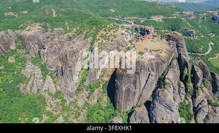 Luftbild des Meteora-Klosterkomplexes, der auf riesigen Klippenfelsen thront, umgeben von einer üppigen grünen Tallandschaft Kalabaka Thessalien Griechenland Reisebildmaterial Stockfoto