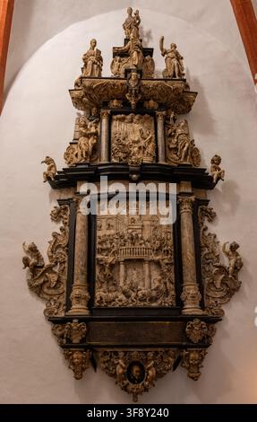 Detailliert geschnitzte Epitaph und Gedenkmal-Kunstwerke, die an einer Wand in der St.-Thomas-Kirche in Leipzig montiert sind, mit bildhauerischen Figuren und Reliefszenen. Stockfoto