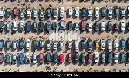 Zerschredderte Autos füllen einen großen Schrottplatz, gesehen von oben, was Recycling und Abfallmanagement betont Stockfoto