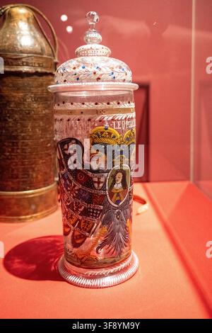 Aschaffenburg, Deutschland - 18. Jul 25: Ornamente bemalter Glaskrug mit heraldischem Adler und Porträt, ausgestellt im Johannisburg-Palast in Aschaffenburg Stockfoto