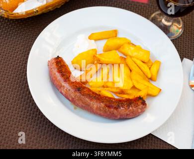 Saftig geröstete Botifarra mit gebratenen Kartoffeln Stockfoto