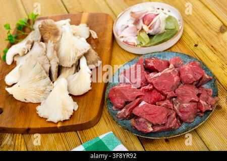 Rohe Kalbfleischstücke, Gewürze und Austernpilze. Stockfoto