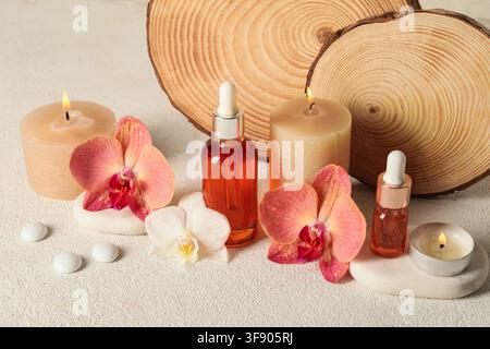 Spa-Umgebung mit ätherischen Ölen, brennenden Kerzen und Orchideenblüten für Entspannung und Wohlbefinden Stockfoto