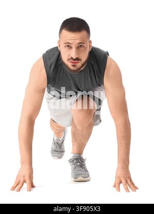 Entschlossener athletischer Mann in Startposition bereit für Fitness- und Sporttraining, isoliert auf weißem Hintergrund Stockfoto