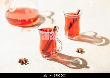 Rote Teekarotte in Gläsern Armudu und Gewürze. Hartes Sonnenlicht Stockfoto