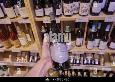 Eine Hand präsentiert eine Flasche Rotwein Bertoldi Gran Passione in einem Supermarkt, Alkoholkonsum, Kauf, Einkauf, Flasche, Glasflasche, Alkohol, sein Stockfoto