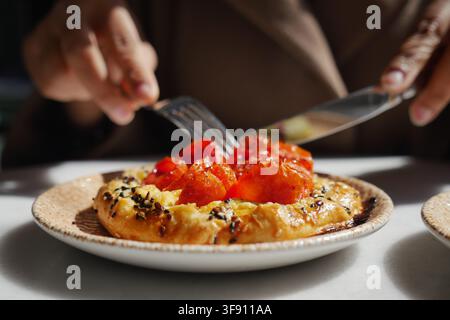 eine herzhafte Tomaten-Tarte-Tatin, serviert auf einem gesprenkelten Keramikteller Stockfoto