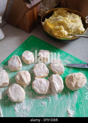 Schritt-für-Schritt-Prozess zur Herstellung von hausgemachten Kuchen, der rohe Teigbällchen und herzhafte Füllung auf der Küchenarbeitsplatte zeigt, Stockfoto Stockfoto