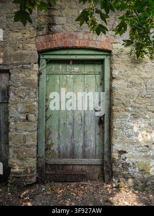 Alte verwitterte grüne Tür, ein Eingang zu einem Hintergarten, Stony Stratford, Buckinghamshire, UK Stockfoto