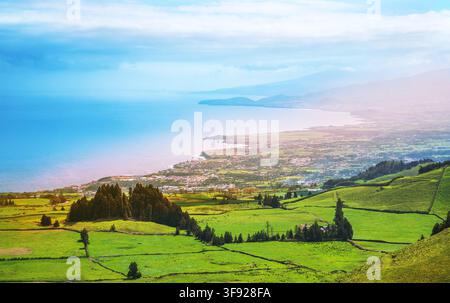 Luftaufnahme aus großer Höhe von üppigen grünen Weideflächen entlang der Küste mit Blick auf den Atlantischen Ozean und die Berge auf São Miguel, Azoren, Por Stockfoto