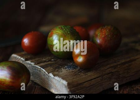 Frische nasse Heirloom-Tomaten auf rustikaler Holzplatte Stockfoto