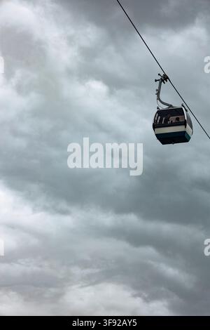 Gondel mit Passagieren vor einem stürmischen Himmel Stockfoto