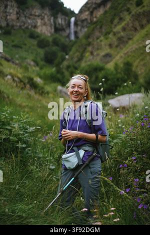 Zufriedene Wandererin lächelt in einem Bergtal Stockfoto