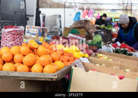 Nahaufnahme von farbenfrohen Zitrusfrüchten und Kisten mit frischem Gemüse auf einem Bauernmarkt, die Essenz gesunder Lebensmittel-einkäufe und Gemeinschaft einfangend Stockfoto
