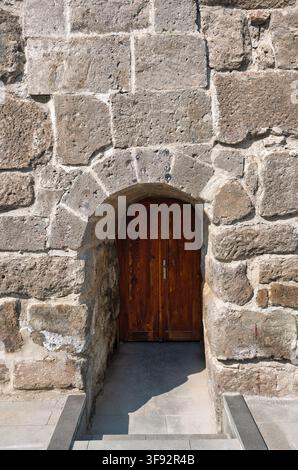 Architektonisches Detail einer alten Holztür, eingerahmt von einem historischen Steinbogen am Kayseri Castle, Kayseri, Türkei Stockfoto