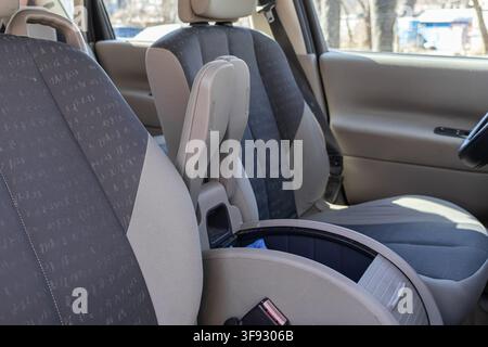 Leerer Aufbewahrungsbehälter in der Mittelkonsole eines Autoinnenraums mit grauen Stoffsitzebezügen, der funktionelles Automobildesign und ein sauberes, aufgeräumtes Spa veranschaulicht Stockfoto