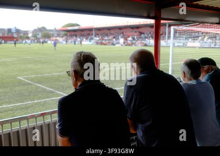 Zuschauer beobachten ein Fußballspiel von der überdachten Tribüne im Sussex Transport Community Stadium, dem Heimstadion von Worthing FC, in Worthing, West Sussex Stockfoto