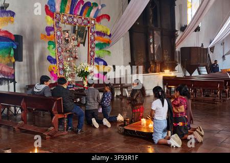 Einheimische beten zu einer Statue eines Heiligen, Innenaufnahme der Kirche Iglesia de Santo Tomás, Chichicastenango, Guatemala, Mittelamerika Stockfoto