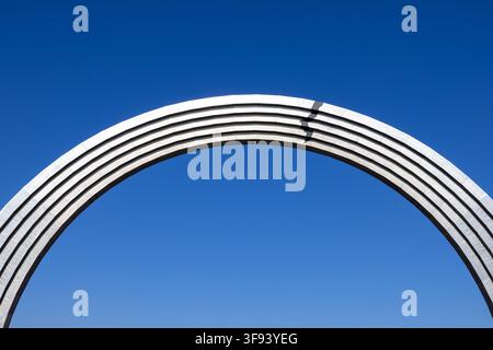 Kiew, Ukraine - 15. März 2026: Gebogene Stahlarchitektur bildet einen eleganten Bogen vor einem tiefblauen Himmel und bietet ein klares minimalistisches Ästhetik-Symbol Stockfoto