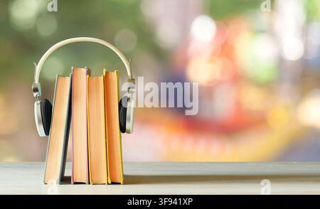 Hörbuch-Konzept mit Büchern und Kopfhörern, Hörbuch-Konzept mit Büchern und Kopfhörern, glatter, unscharfer Hintergrund. Stockfoto