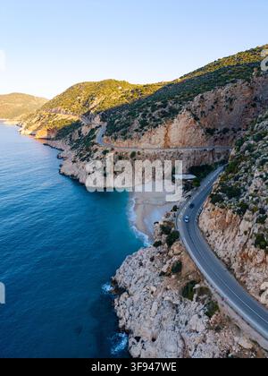 Eine atemberaubende Luftaufnahme zeigt die kurvenreiche Straße, die sich entlang der felsigen Küste schlängelt, und enthüllt das türkisfarbene Wasser und die sandige Weite von Kaputas Stockfoto