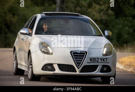 Milton Keynes, UK - 10. August 2026: 2012 weißer Alfa Romeo Giulietta fährt auf einer britischen Straße Stockfoto