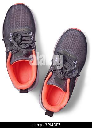 Paar graue Laufschuhe isoliert auf weißem Hintergrund, hellorangefarbenes Innenfutter und geschnürte Schnürsenkel Sportschuhe, Ansichtsaufnahme von oben Stockfoto