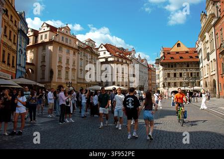 Prag, Tschechische Republik – 28. Juli 2026: Touristen überqueren den Altstädter Ring, umgeben von historischen Gebäuden und dem Haus zur Minute. Stockfoto