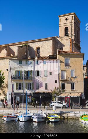 Farbenfrohe Ufergebäude und die Église Notre-Dame-de-l'Assomption spiegeln sich im Hafen von La Ciotat, Provence, Frankreich. Stockfoto