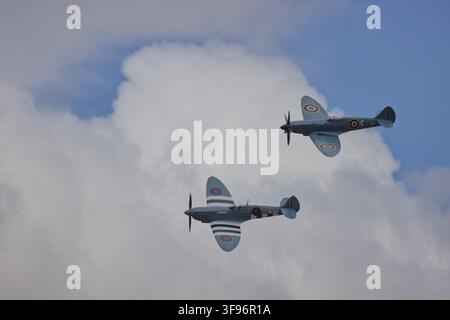 RAF FAIRFORD, GLOUCESTERSHIRE, VEREINIGTES KÖNIGREICH – 18. JULI 2025: Zwei historische RAF-markierte Propellerflugzeuge fliegen in Formation vor Wolken. Stockfoto