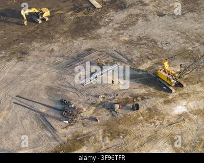Luftaufnahme des Abfall-zu-Energie-Fertigungsprojekts mit schwerer Baumaschinerie, Baggern, Kränen und Arbeitern vor Ort in Kecamatan Denpasar S Stockfoto