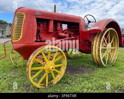 Restaurierter Massey-Harris-Landtraktor aus dem Jahr 1938 mit rotem Körper, gelben Stahlrädern und freiliegendem Motor, ausgestellt in Plaisance, Quebec, Kanada. Stockfoto