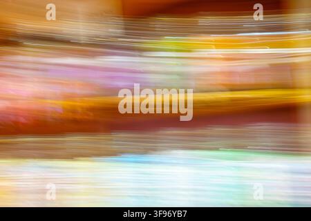 Farbe und Bewegung aus einem Süßwarenladen: horizontale absichtliche Kamerabewegung über die Reihe der Süßigkeiten erzeugt ein helles und begeistertes Muster Stockfoto