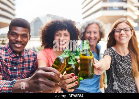 Team trinkt Bier zusammen auf der Dachterrasse des Büros Stockfoto