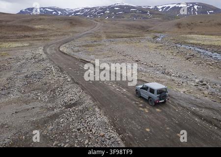 Luftbild einer isländischen Berg-Fernstraße, karge vulkanische Hochlandlandschaft und ein 4x4-Fahrzeug, Island Stockfoto