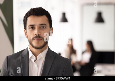 Headshot-Porträt eines jungen erwachsenen Geschäftsmannes, der selbstbewusst im Büro steht Stockfoto