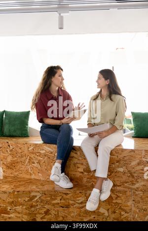 Frauenkolleginnen besprechen ein Projekt oder Dokumentdetails im Coworking Stockfoto