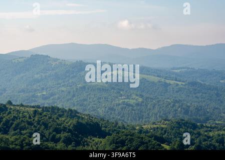 Diese Weitwinkelaufnahme fängt eine weitläufige Naturszene aus einer hohen Perspektive ein und zeigt Schichten von Hügeln und Tälern mit üppiger Vegetation a Stockfoto