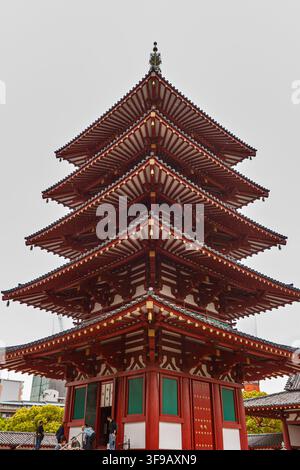 Eine niedrigwinklige Ansicht von Touristen, die die historische fünfstöckige Pagode Gojunoto im Tempelkomplex Shitennoji in Osaka, Japan, besuchen. Stockfoto