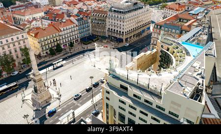 Luftbild des Rossio-Platzes mit seinem zentralen Obelisken, historischer Architektur, belebten Straßen und einem Dachpool in Lissabon, Lissabon, Portugal. Stockfoto