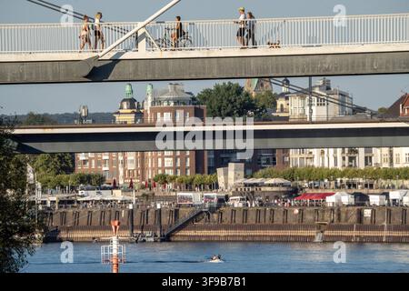 Blick vom Medienhafen über den Rhein in Richtung Altstadt, Menschen überqueren die Rheinkniebrücke, Düsseldorf, 14. August 2026 Deutschland, Düsseldorf, 14. August 2026, Blick vom Medienhafen über den Rhein in Richtung Altstadt, Menschen überqueren die Rheinkniebrücke, abends um 19:10 Uhr, ein heißer Sommertag geht zu Ende, schönes Wetter, Hochsommer, Hitzewelle, Sommer, Wetter, Nordrhein-Westfalen, NRW, *** Blick vom Medienhafen über den Rhein in Richtung Altstadt, Menschen überqueren die Rheinkniebrücke, Düsseldorf, 14. August 2026 Stockfoto