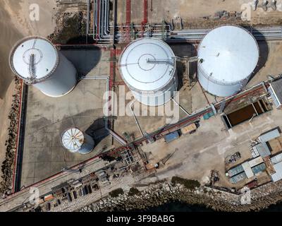 Luftbild von LNG-Silos und industrieller Infrastruktur mit komplexen Rohrleitungssystemen in der Nähe der felsigen Küste in Matosinhos, Porto, Portugal. Stockfoto