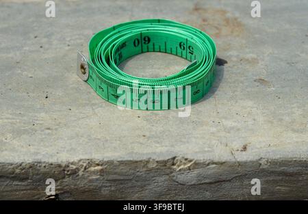 Grünes Maßband auf Betonoberfläche Stockfoto