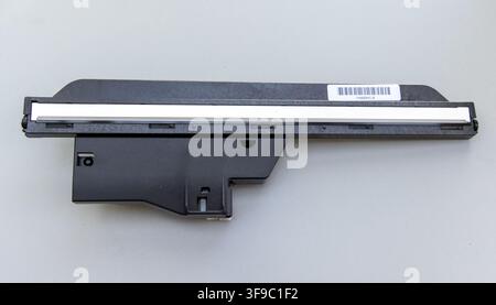 Ein schwarzes elektronisches Bauteil mit einem Barcode ruht auf einem hellgrauen Hintergrund Stockfoto