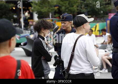 Blonde schwedische Polizeibeamtin befragt einen Mann am Sergels torg, Drottninggatan, Stockholm, Schweden. Stockfoto